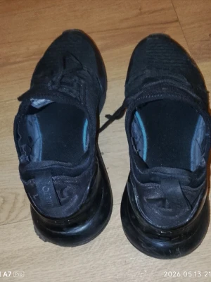 Svarta Nike Air Max sneakers - Snygga helsvarta Nike Air Max sneakers med stickad ovandel och klassisk Air Max-sula. Skorna har lågt skaft, snörning och diskreta loggor på plösen och hälen. Perfekta för en sportig och urban stil.