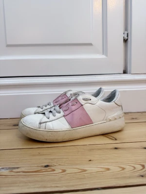 Valentino Open - Vita Valentino Opens med  rosa läderdetalj över snörningen och klassiska nitar på hälen. Perfekta till sommaren! Använda, syns framförallt på sulan, därav ett lägre pris som dessutom är förhandlingsbart. Tveka inte att skriva vid minsta fundering.