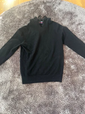Svart Kashmir hoodie  - Säljer nu denna snygga kashmirhoodien från William de faye. Tröjan är lite nopprig men fortf gott skick. En som har släppt lite i kragen (se bild). Passar M. 45% Kashmir. Bara att höra av sig med frågor eller funderingar! 
