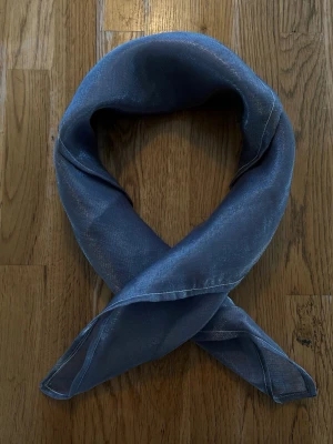 Silvrig scarf i transparent tyg - Snygg silvrig/grå scarf i glansigt och transparent material🩶🤍 Skitsnygg och tidlös detalj som piffar upp en outfit både till vardags och på fest!! Går att bära i t.ex. håret, på väskan eller runt halsen. Scarfen är sydd med lila tråd vilket blir en cool detalj.  Scarfen är handgjord och lokaltillverkad av återbrukade tyger vilket gör den miljövänlig.  Hör av dig vid frågor✨