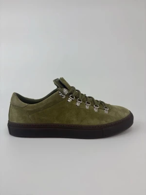 Olivgröna Diemme mockasneakers med metallhakar - Vi har dem i storlek 41 och 42. Snygga sneakers i olivgrön mocka med robust svart sula och coola metallhakar för snörningen. Skorna har en clean och modern look med outdoor-inspirerade detaljer. Perfekta för dig som vill sticka ut med stilrena men unika sneakers.