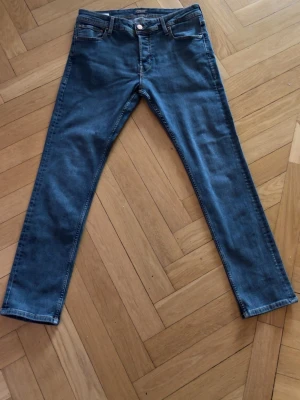  jeans Jack & jones  - Snygga mörkblå jeans med rak passform och metallknapp i midjan. Perfekta för en avslappnad och stilren look. Materialet är klassisk denim i bomull. Ny pris 500