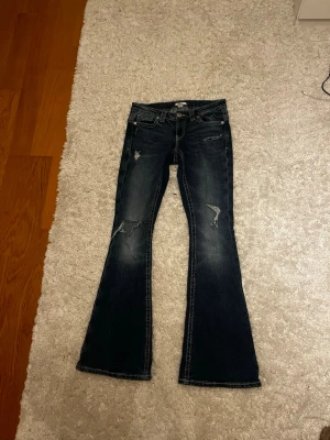 Mörkblå Gina tricot jeans med slitningar - Trendiga Gina tricot jeans, lågmidjade och nästan aldrig använda. De är ifrån Gina Young 14+ i storlek S. Tar emot bud men inget orimligt 