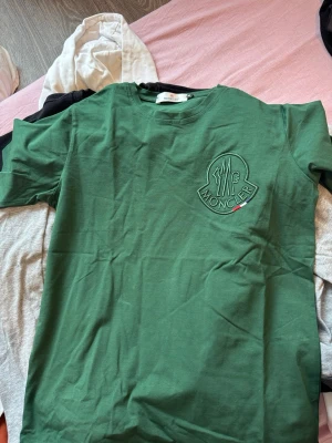 Grön Moncler t-shirt med broderad logga - Snygg grön t-shirt från Moncler med stor broderad logga på bröstet. Passar s/m