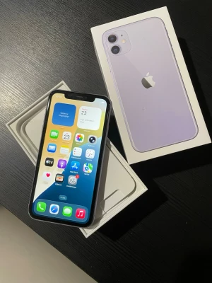 Lila iPhone 11 med originalkartong - Säljer en snygg lila iPhone 11 från Apple. Telefonen har en stilren design med rundade hörn, glasbaksida och aluminiumram. Kommer i originalkartong. Perfekt för dig som vill ha en modern smartphone med dubbla kameror och stor skärm.