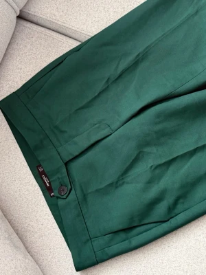 Gröna shorts från Mango Basics - Stilrena gröna shorts från Mango Basics med klassisk knappstängning och diskreta fickor. Shortsen har en rak passform och är tillverkade i ett mjukt bomullsmaterial som passar perfekt till varma dagar.
