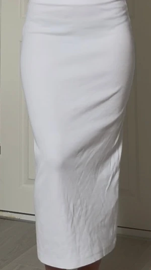 Vit långkjol i bomull - Säljer en enkel och stilren vit långkjol i mjukt bomullsmaterial. Kjolen har en rak passform och hög midja som ger en clean och modern look. Perfekt att matcha med crop tops eller oversized tröjor för en trendig outfit.