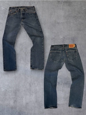 Sinnessjuka Levi's 501 i straight fit - Klassiska blå Levi's 501 jeans med rak passform och fem fickor. Jeansen har knappgylf, ikonisk läderpatch bak i midjan och är tillverkade i slitstark denim. Perfekta för en avslappnad och tidlös stil. Mått:längd 100cm, midja 40cm, benöppning 20cm