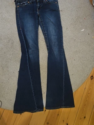 Joey true religion W25 - Mörkblåa true religion i färgen muddy waters. Jättebra kvalitet bortsett ifrån att de är lite missfärgade längst ner men det syns inte när de är på. Priset kan diskuteras, skickar iväg snabbt