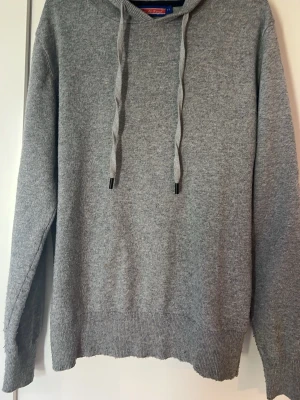 Grå stickad hoodie med huva - Mysig grå stickad cashmere hoodie från William de Faye med långa ärmar. Tröjan är i storlek S och i bra skick! Skriv vid funderingar🤝