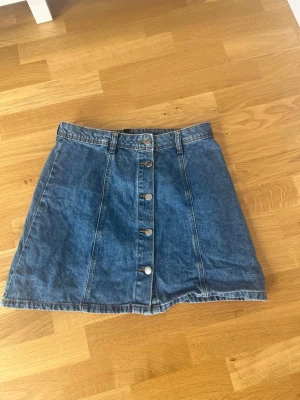 Jeanskjol med knappar från H&M Divided - Mid-rise kjol, en aning liten is Torkel så den passar även om man har S/36.