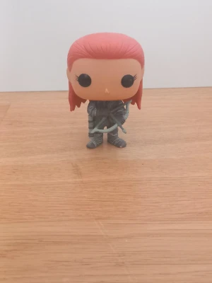Funko Pop! Game of Thrones – Ygritte #18 (Vaulted) - Officiell Funko Pop Vinyl-figur av Ygritte från Game of Thrones. Figuren har hennes ikoniska orange/röda hår, vildling-outfit med pälsdetaljer och pilbåge. ✨ Detaljer: • Karaktär: Ygritte • Funko Pop #18 • Utgiven 2014 • Vinyl, ca 10 cm • Vaulted/discontinued (tillverkas inte längre) • Utan originalkartong Mycket fint skick. Har förvarats varsamt och är perfekt för Game of Thrones-fans och Funko Pop-samlare. Se bilder för skick. 📦 Packas noggrant vid frakt.