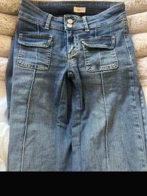 Blå utsvängda jeans från Nelly - Dessa jeans är i mycket bra skick och bara väntar på ett nytt hem! Har sytt in dom vid grenen och ner längst låren så att dom blir mer low waist, längre, och sitter bättre i både låren och rumpan. Detta kanske gör så att priset sänks, men jag vill lägga upp dom för 250 och ta emot pris förslag. Tveka inte att fråga! 💕Storlek 34!🥰