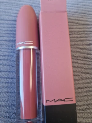 MAC Del Rio läppstift rosabrun - MAC Del Rio läppstift i en snygg rosabrun nyans. Hylsan är i matt rosa plast med silverdetalj och genomskinlig botten. Kommer i originalförpackning med matchande färg. Perfekt för dig som gillar naturliga men markerade läppar.