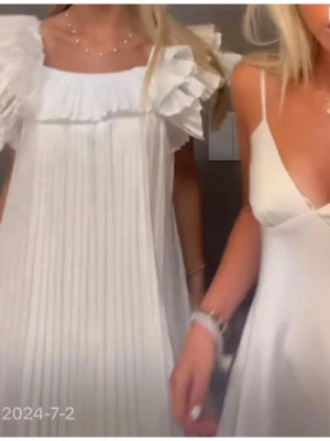 Vit plisserad klänning med volang - Superfin vit klänning med plisserat tyg och stora volangärmar🥰🥰🥰💓💓