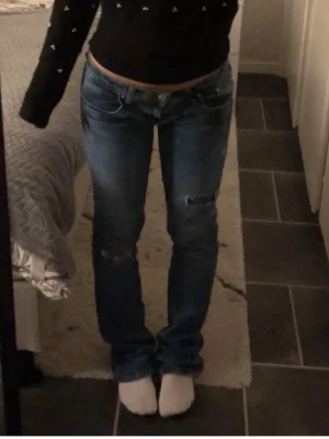 Blå slitna jeans från LTB - Snygga blå jeans från LTB, modell Blue Addicted. Jeansen har en låg midja, raka ben och slitna detaljer på låren och knäna för en trendig look. Klassisk femficksmodell med knappgylf och kontrastsömmar. Perfekta för en avslappnad stil.