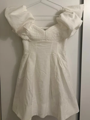 Studentklänning / vit mini klänning - Vit mini klänning från Forever New, Australien. Perfekt som studentklänning. Går att bära både som off shoulder och med ärmarna på axeln. Slutsåld överallt och nypris på 1800kr. Endast testad med alla lappar kvar. Skickar bilder med den på vid intresse 💕