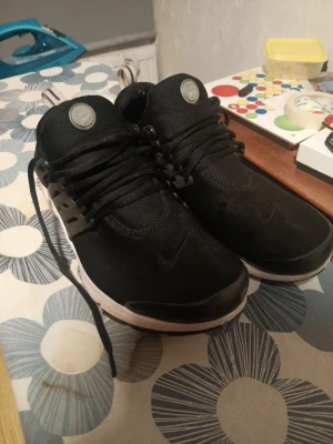Svarta Nike Air Presto sneakers - Säljer svarta Nike Presto (stl 46). Sjukt sköna och lätta i mesh-material. Överlag bra skick men det finns två små hål i tyget (se bild), inget som stör vid användning. Jag tvättar dem noga innan jag skickar så de är helt fräscha vid leverans. Återigen lägger jag upp denna annons då det finns massa oseriösa köpare som skriver att dem är intresserade men ger inget svar där efter! ,hör av dig om du är intresserad!  