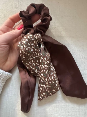 Brun scrunchie med rosett - Söt brun scrunchie. Perfekt för att piffa till håret med en trendig accessoar. Har bundlerabatt vid köp av fler varor🥰