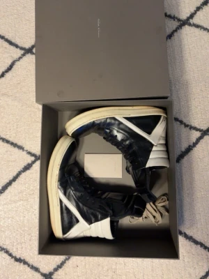 Rick Owens skor - Säljer ett par riktiga höga Rick Owens i storlek 42, svart och vitt läder. Medföljer: skor, låda, extra snören, en liten broschyr kom privat för fler frågor eller funderingar mvh 🥰