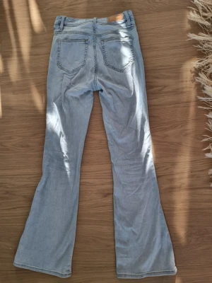 Ljusblå bootcut jeans - Säljer ett par ljusblå bootcut jeans från veromoda i storlek S i midjan och 33 i längden, väldigt stretchiga