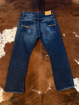 Nudie regularalf bootcut - Tjena! Säljer dessa riktigt snygga nudie bootcut, byxorna är i modellen RegularAlf och är i storlek W34/L30, byxorna på bild 3 är ej samma jeans det är bara så man ska få se passform, hör av dig vid funderingar!🙌