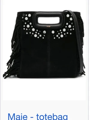 Svart handväska med fransar från Maje - Snygg svart handväska i mocka från Maje med dekorativa silverfärgade nitar upptill och fransar längs sidorna. Väskan har ett fyrkantigt handtag och en avtagbar axelrem för olika stilar. Perfekt accessoar för en trendig look. Man får med både påse och band. Väskan ligger på 2100kr då jag köpte den för mindre än ett år sedan för 4000kr. 