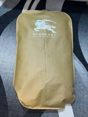 Svart pufferjacka från Burberry Jacket - Snygg svart pufferjacka från Burberry jacka med huva och dragkedja framtill. Jackan har två sidofickor med dragkedja och logga på ärmen. Perfekt för kalla vinterdagar och riktigt skön att bära tack vare det vadderade materialet. Funkersr som väst oxå