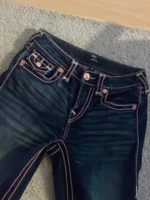 True Religion jeans med kontrastsömmar - Jättefina True religion jeans i storlek 23 använda 2-3 gånger men säljes pågrund av att de he blivit försmå. 