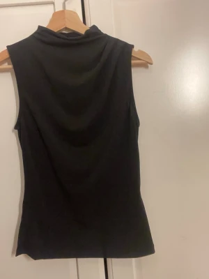 Svart ärmlös topp från PIECES - Snygg svart topp från PIECES. Alldrig använd utan lapp 