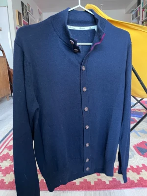 Mörkblå merinoull cardigan från Stenströms passar S - storlek S eller stor XS, trots att det står storlek M. 100% merinoull. Snygg mörkblå kofta från Stenströms med klassisk passform. Tröjan har långa ärmar, knappar och gjord av merinoull. Perfekt för lager-på-lager och stilrena outfits.