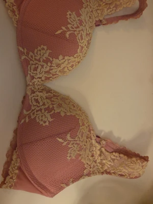 Rosa Intimissimi bh  - Snygg rosa bh med vadderade kupor och vit spetsbrodyr i blommigt mönster. Justerbara axelband och hakknäppning bak. Materialet är en mix av mjuk textil och spetsdetaljer som ger en romantisk look. Köpt på vinted men aldrig använt själv. Lappen är inte kvar men skulle gissa på storlek 85D. Priset går att diskutera!
