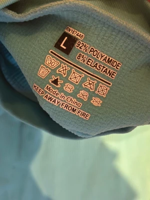 Turkos ribbad kortklänning - En turkos ribbad kortklänning med korta ärmar och liten krage. Klänningen är tillverkad i stretchigt material av 92% polyamid och 8% elastan, vilket ger en bekväm och figurnära passform. Perfekt för dig som gillar enkel och stilren design.