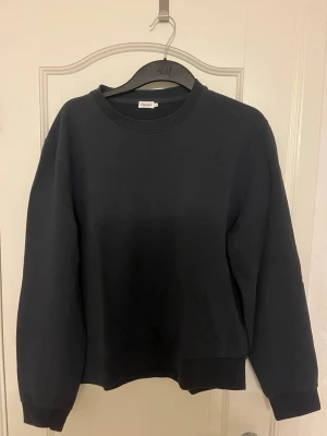 Mörkblå sweatshirt från Filippa K - En enkel mörkblå sweatshirt från Filippa K med rund halsringning och ribbade muddar vid ärmslut och nederkant.