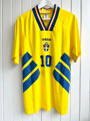 Martin Dahlin - Sverige - VM 1994 - Säljer en klassiska fotbollströja, Martin Dahlins svenska hemmamatchtröja från VM 1994 i USA. Tröjan är en reprint i nyskick.  Aldrig använd.    Storlek: XL.