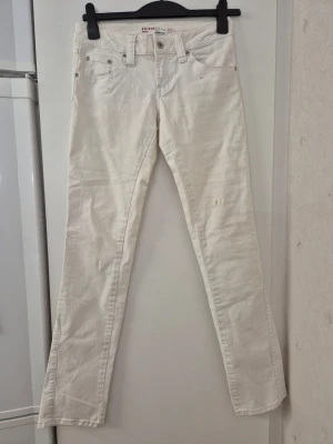 Jeansbyxor - Säljer ett par vita jeansbyxor från Ichi med klassisk femficksmodell och snygga detaljer på bakfickorna. Jeansen har normal midja och är tillverkade i ett mjukt bomullstyg med lite stretch. Perfekta för dig som vill ha en clean och fräsch look. Har några fläckar.