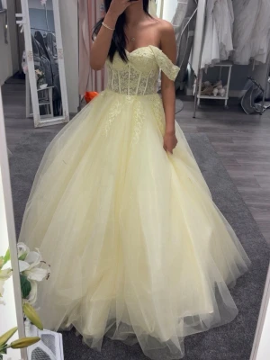 Balklänning  - Säljer min helt nya ljusgula balklänning i storlek 32. Superfin glittrig med snörning i ryggen så storleken går att justera. Den är inte uppklippt än så längden går också att justera. Den är aldrig använd och köpt på DreamDesigns i Motala. Det är bara att höra av sig vid frågor!💛