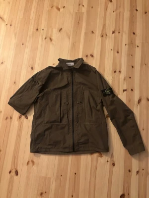 Stone Island Jacka - En lätt jacka (overshirt isch) från Stone Island. Köpt för ca 2 månader sen och använt fåtal gånger, perfekt skick, som ny!