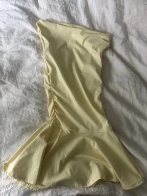 Ljusgul asymmetrisk klänning - Trendig ljusgul kortklänning med asymmetrisk one-shoulder design och volang nertill. Säljs inte längre på Zaras hemsida!