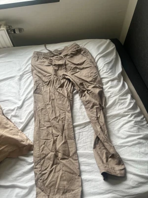 Beiga linnebyxor med resårmidja - Säljer ett par beiga linnebyxor med resår och dragsko i midjan. Byxorna har raka ben och är tillverkade i ett lätt och luftigt linnematerial, perfekta för varma dagar. Enkel och avslappnad stil som passar till det mesta. Vid fler funderingar eller info är det bara att skriva//Wille