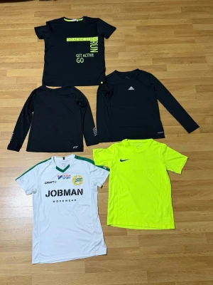 Träningspaket i mycket bra skick! - 5 träningsplagg i mycket bra skick, perfekta för fotboll, gym, löpning eller annan träning.  Innehåller: - Adidas underställ – storlek 152 - PRO Touch underställ – storlek 134/140 - Nike träningströja – M (Nike Barn, 137–147 cm) - Hammarby fotbollströja – storlek 158/164 - Svart träningströja med grön text – storlek 158/164  Pris: 299 kr för hela paketet. 🏷️ Rabatt vid köp av flera plagg!