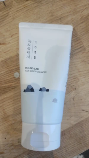 Round Lab 1025 Dokdo Cleanser - Mild ansiktsrengöring från Round Lab, 1025 Dokdo Cleanser. Tuben är vit med ljusblå detaljer och illustration av berg och hav. Innehåller 150 ml och är tillverkad i Korea. Passar för daglig rengöring av huden.