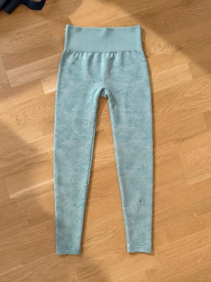 Ljusgröna seamless leggings - Snygga ljusgröna leggings med hög midja och sömlös design. Materialet är stretchigt och mjukt, perfekt för träning eller chill. Diskret mönster i tyget ger en extra touch. Passar dig som gillar bekväma och stilrena plagg.