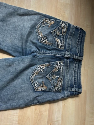 Bootcut jeans med coola fickor!  - Pris kan förhandlas! Riktigt coola jeans i märket telepatia som jag köpte i USA. De har jättemånga och fina detaljer på fickorna, knapparna och sömmarna. De är i väldigt bra skick förutom att knappen åker av ibland men det är nog väldigt lätt att sy fast. 