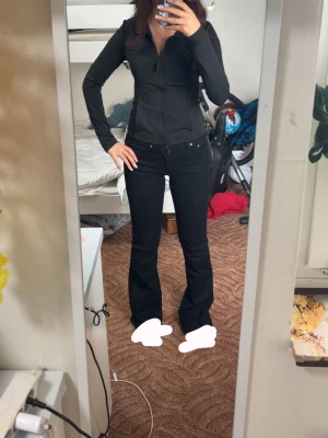 Svarta bootcut jeans från Gina med utsvängda ben - Säljer ett par svarta bootcut jeans med klassisk femficksdesign och utsvängda ben. Jeansen har normal midja och stängs med dragkedja och knapp. Perfekta för dig som gillar en tidlös och trendig look.