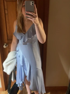 Ljusblå siden volangklänning  - Ljusblå siden klänning med volanger från märket Express. Storlek S, använd handfull av gånger så i bra skick!