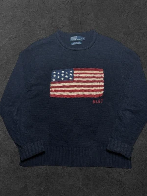 Vintage Polo Ralph Lauren USA grovstickad tröja - herr strl M (L) - Säljer en grovstickad vintage Polo Ralph Lauren tröja med USA-flagga brodering över bröstkorgen i marinblå färg i storlek M (Passar som L)  👕 Märke: Polo Ralph Lauren 📏 Storlek: M (passar som L) 🎨 Färg: Marinblå 🧵 Material: 47% bomull, 47% linne, 6% silke 📐 Mått: Längd 68 cm, bredd 55 cm 📍 Skick: Mycket bra skick (se bilder)  💬 Har du några frågor är det bara att höra av dig! 💰 Vid snabb affär kan priset diskuteras. 📦 Skickar alltid inom 24 timmar!