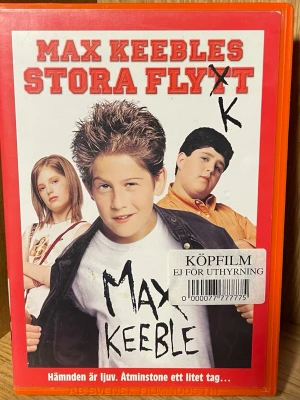 Max Keebles Stora Flytt VHS - VHS med titeln 'Max Keebles Stora Flytt'. Omslaget är rött och vitt med bilder på huvudkaraktärerna. Filmen är en komedi från Walt Disney Pictures och har svensk text. Fodralet är av plast och har etikett för köpfilm.