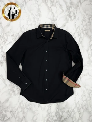 Burberry Skjorta M - Svart Burberry skjorta i storlek M i mycket bra skick. Skjortan är självklart äkta. Är du osäker på äkthet hänvisar jag gärna till bra källor/guider. Tveka inte på att höra av dig för fler frågor eller vid minsta fundering! Skick: 9/10