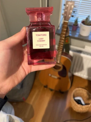 Tom Ford Lost Cherry parfym 100 ml - Tom Ford Lost Cherry Eau de Parfum i en lyxig, fyrkantig röd glasflaska med elegant etikett. Flaskan rymmer 100 ml och har en unik, djup röd färg som verkligen sticker ut. Perfekt för dig som gillar exklusiva och fruktiga dofter.